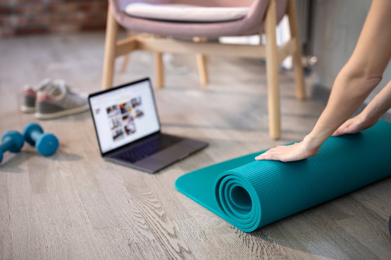 Person prepares for online activity with yoga mat