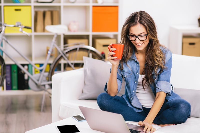 Woman sitting on sofa using a laptop