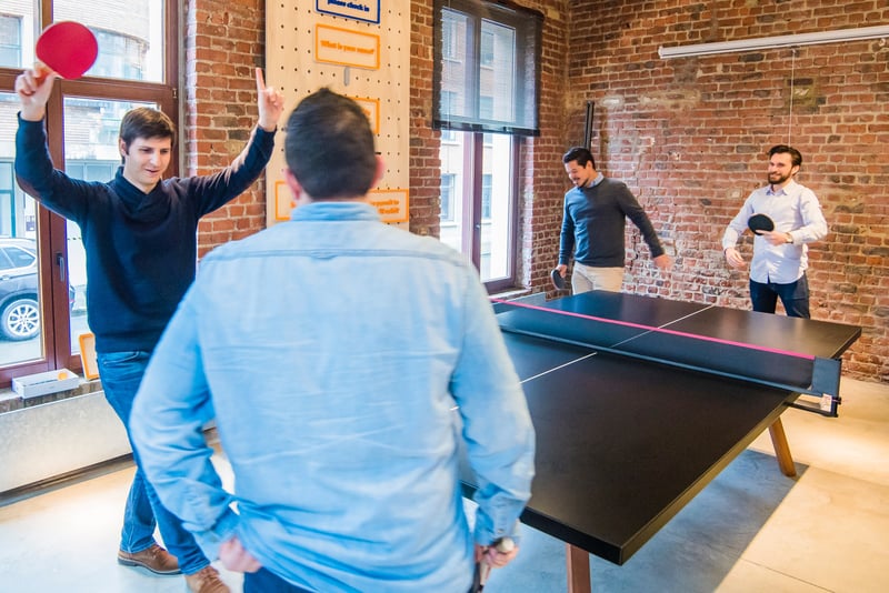 group of men playing table tennis at work