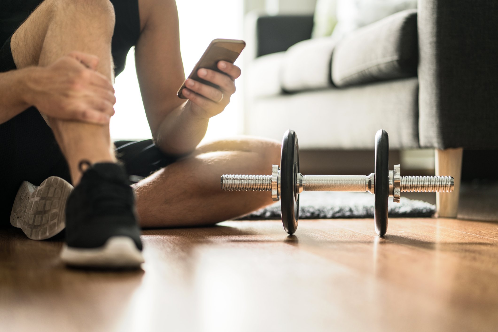 Man using smartphone during workout at home