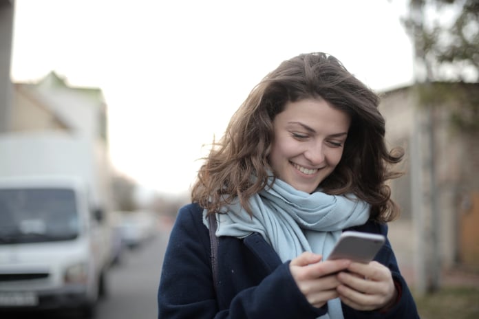 Smiling woman wearing scarf with cell phone
