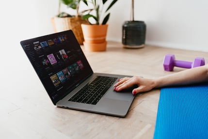 Woman with laptop and exercise equipment