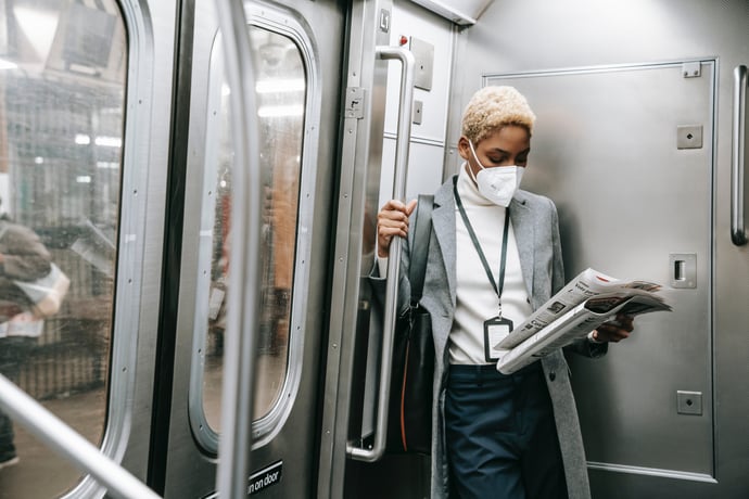 Woman wearing mask riding subway to work