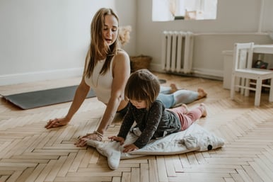 Young woman with child at home practicing yoga