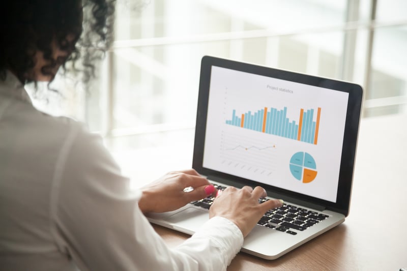 woman looking at graphs on laptop