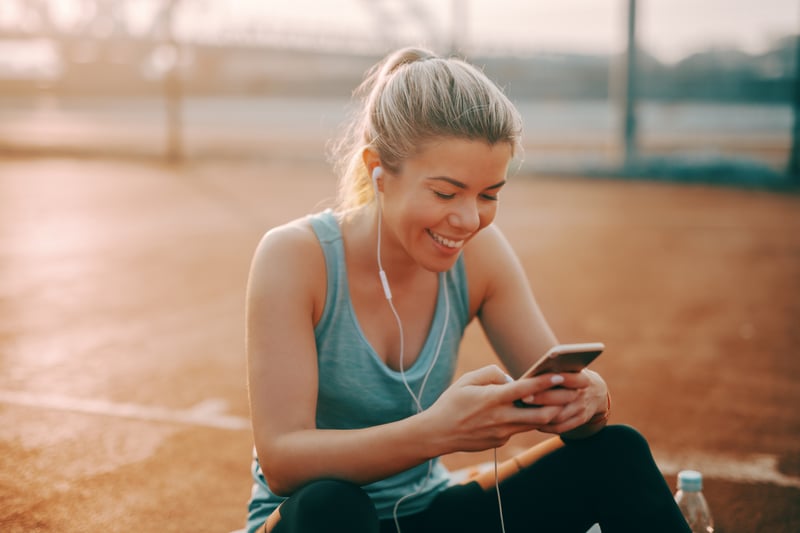 woman smiling while using smartphone