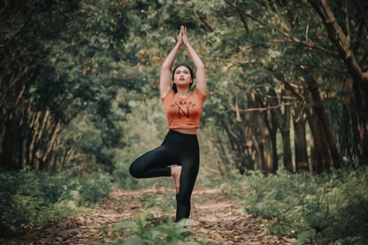 Woman tree pose position in the forest