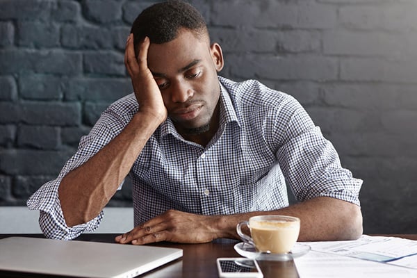 young black man stresses while working from home