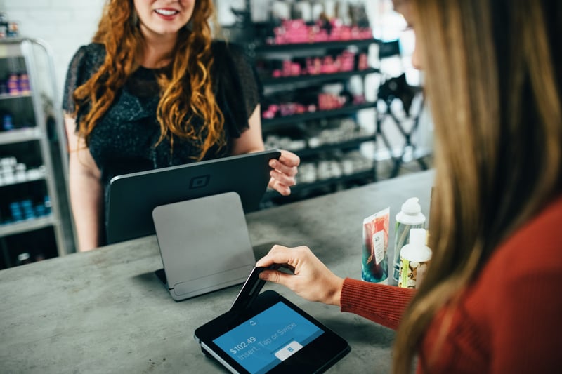 young woman making a purchase with credit card on mobile POS